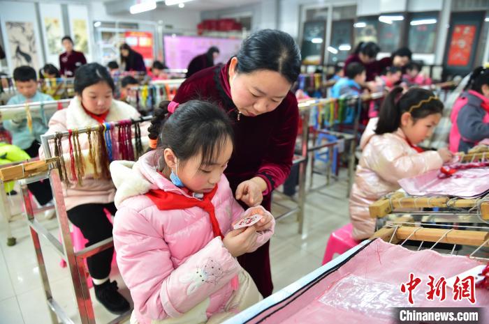江西省級非遺豫章繡傳承人手把手指導小學生繡制2022年北京冬奧會吉祥物“冰墩墩”形象?！∮髟屏?攝