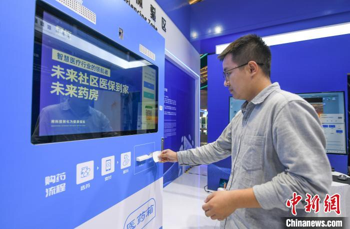 在“中國醫(yī)保 一生守護”展區(qū)，民眾體驗在24小時未來藥房憑“處方”取藥 王剛 攝