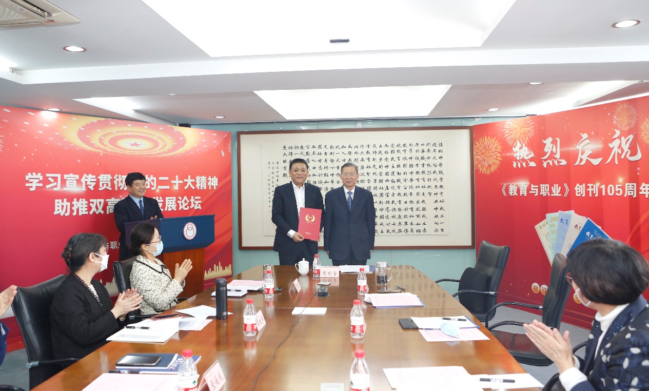 郝明金為《教育與職業(yè)》雜志編委代表陳曉明頒發(fā)聘書(shū)。中華職教社供圖