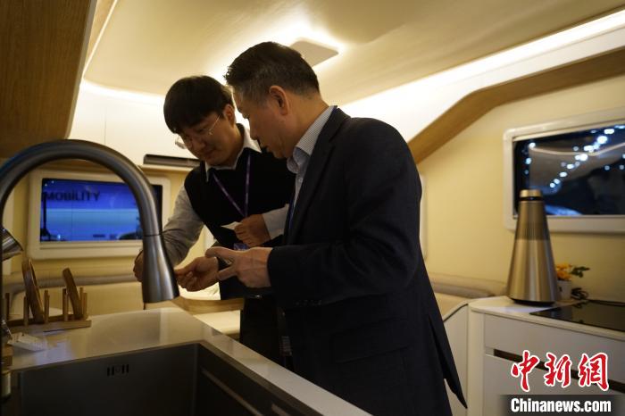 圖為參展商向觀眾介紹房車內(nèi)部設(shè)計(jì)?！⑿?攝