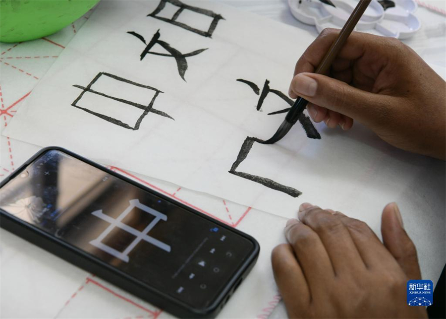 4月18日，肯尼亞學生在內(nèi)羅畢大學孔子學院舉辦的活動上寫毛筆字?？夏醽唭?nèi)羅畢大學孔子學院18日舉辦“中文，增進文明對話”主題活動，慶祝即將到來的第14個聯(lián)合國中文日。肯尼亞學生參與互動，進行書法、剪紙、唱中文歌等活動。新華社記者 韓旭 攝