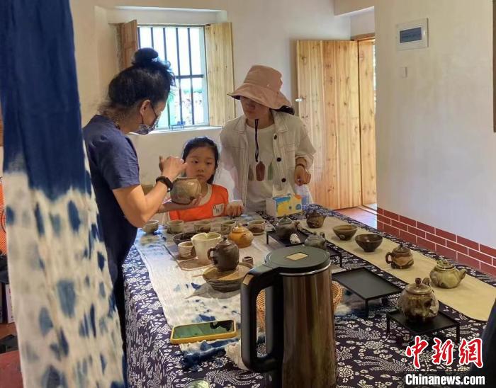 圖為：游客正在咨詢臺灣柴燒作品?！∪~秋云 攝