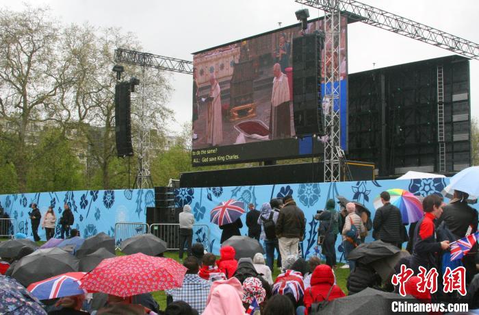 當(dāng)?shù)貢r間5月6日，英國國王查爾斯三世的加冕儀式舉行。民眾雨中觀看儀式。　歐陽開宇 攝