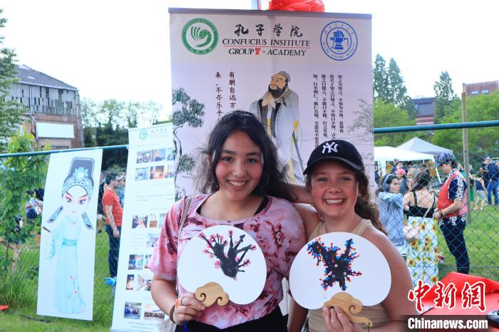 孩子們展示自己的吹墨畫團(tuán)扇作品?！◆斻肟鬃訉W(xué)院供圖