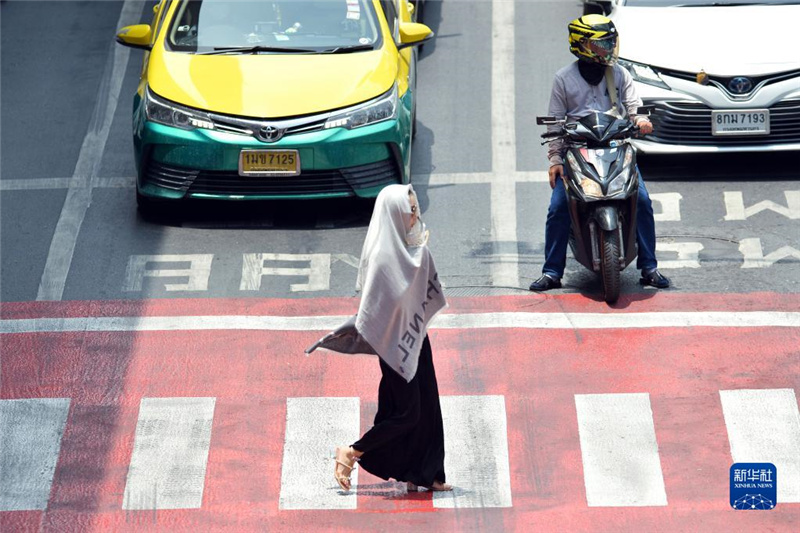 5月17日，行人在泰國曼谷街頭用圍巾遮陽。新華社發(fā)（拉亨攝）