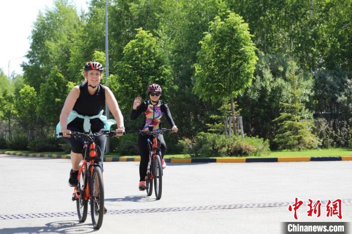 亞信副秘書長遲方(右一)與聯(lián)合國駐哈協(xié)調(diào)員在騎行活動中?！喰琶貢幑﹫D