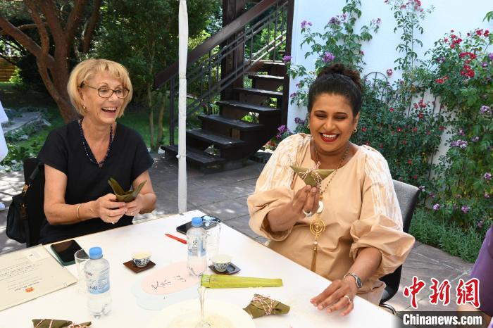 圖為嘉賓展示包粽子成果?！“亓种袊幕行墓﹫D。