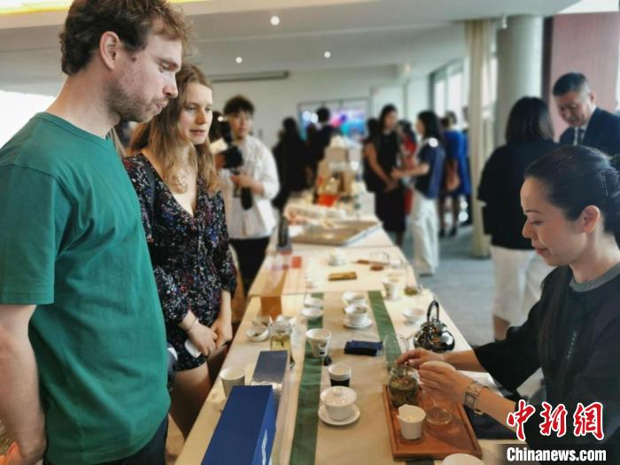 現(xiàn)場觀眾觀看中國展臺茶藝表演、了解茶文化。　靖樹 攝