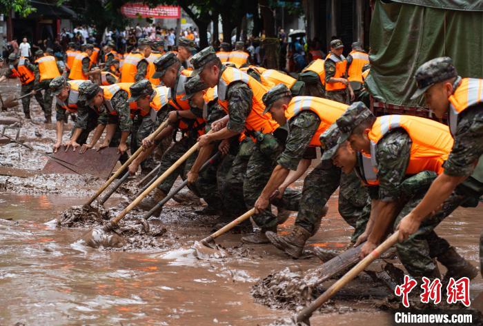 7月4日，萬(wàn)州區(qū)五橋街道，武警官兵清理街道上的淤泥。　冉孟軍 攝