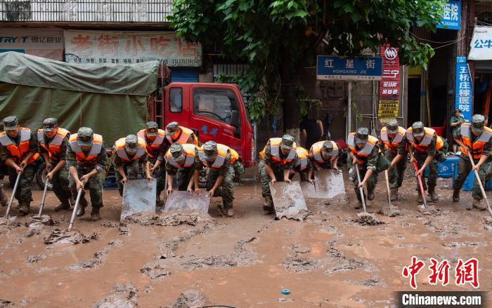 7月4日，萬(wàn)州區(qū)五橋街道，武警官兵清理街道上的淤泥?！∪矫宪?攝