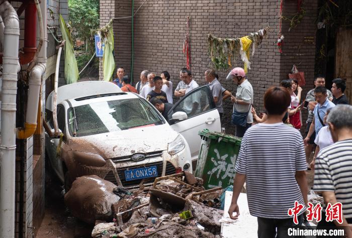 7月4日，萬(wàn)州區(qū)五橋街道，居民救援受困的私家車(chē)?！∪矫宪?攝