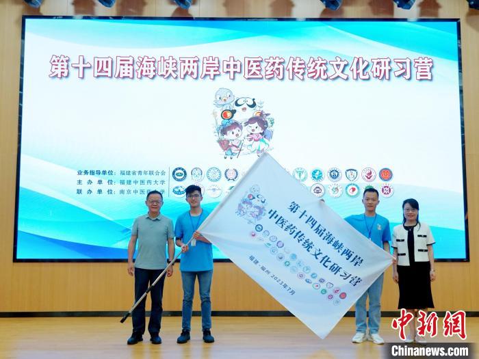 共青團(tuán)福建省委副書(shū)記吳雪(右一)、福建中醫(yī)藥大學(xué)黨委副書(shū)記林羽(左一)為兩岸學(xué)生代表頒授營(yíng)旗。　許燁婷 攝