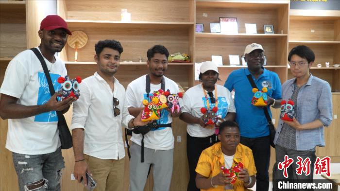 圖為國際青年代表展示親手制作的東營非遺黃河口布偶 ?！↓R魯 攝