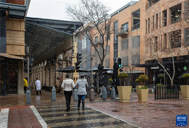 7月10日，在南非約翰內(nèi)斯堡一處商業(yè)區(qū)，人們在雪中行走。新華社記者 張譽東 攝