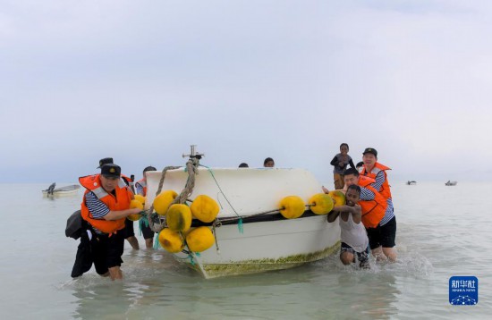 7月21日，中國海軍“和平方舟”號醫(yī)院船醫(yī)護(hù)人員涉水登島，前往基里巴斯一診療點。新華社記者 黎云 攝