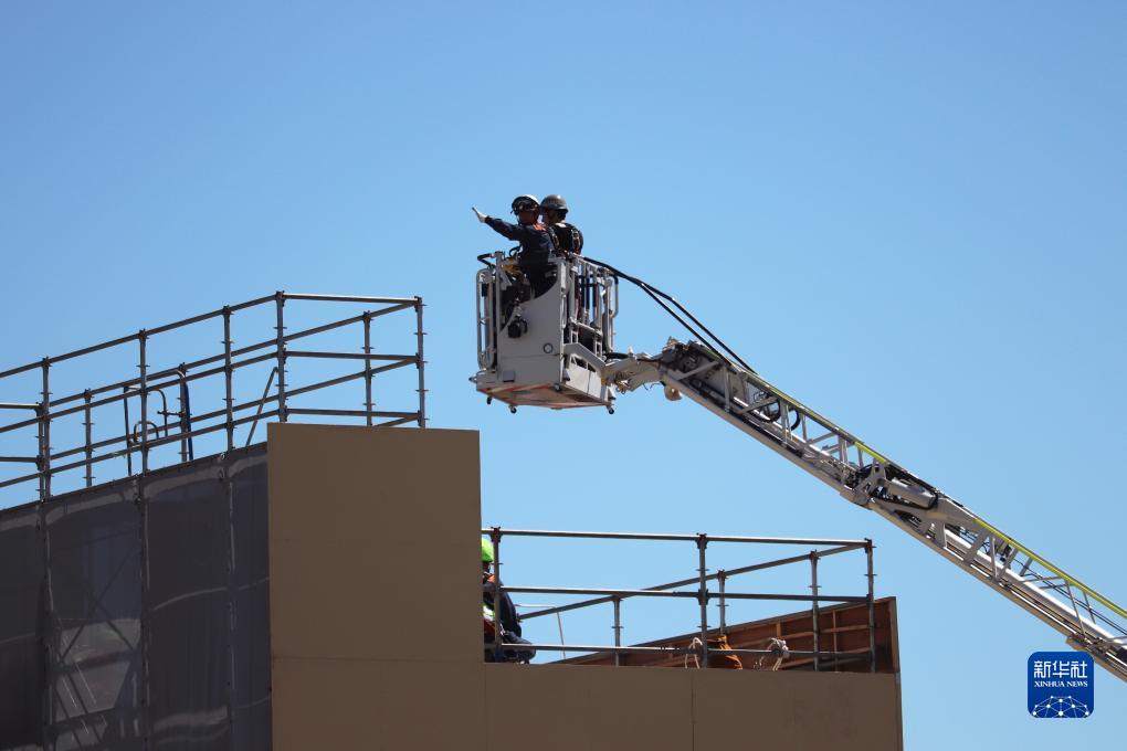 9月1日，在日本神奈川縣相模原市，消防員演練用消防云梯車(chē)救下被困高樓的民眾。9月1日是日本防災(zāi)日。當(dāng)天，日本中央政府及多個(gè)都縣市舉行了防災(zāi)演練，以提高大規(guī)模災(zāi)害發(fā)生時(shí)防災(zāi)機(jī)構(gòu)和市民迅速應(yīng)對(duì)的能力。新華社記者 楊光 攝