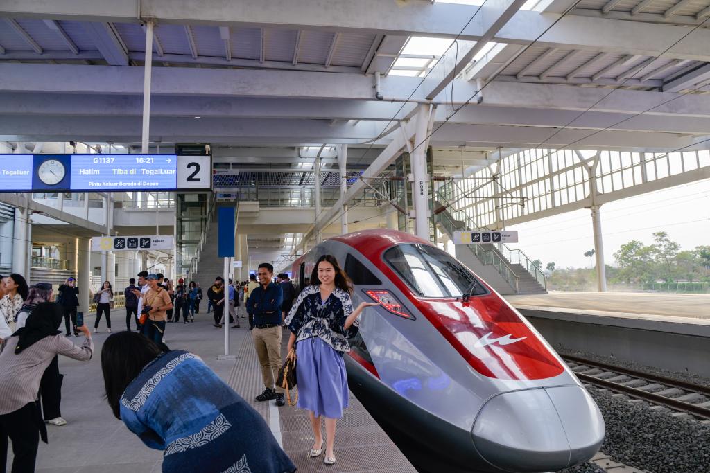 10月17日，在印度尼西亞萬隆德卡魯爾站，乘客在站臺上和雅萬高鐵高速動車組列車合影。