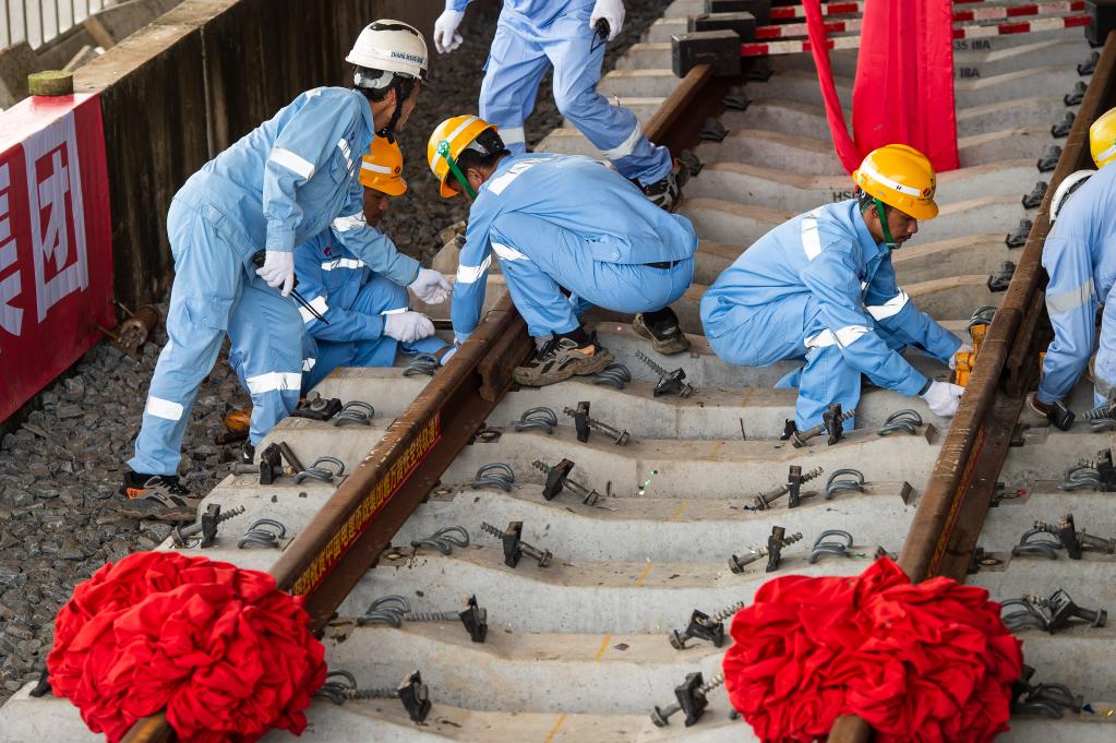 3月31日，在印度尼西亞雅加達雅萬高鐵哈利姆車站，工人鋪設(shè)雅萬高鐵全線最后一根鋼軌。