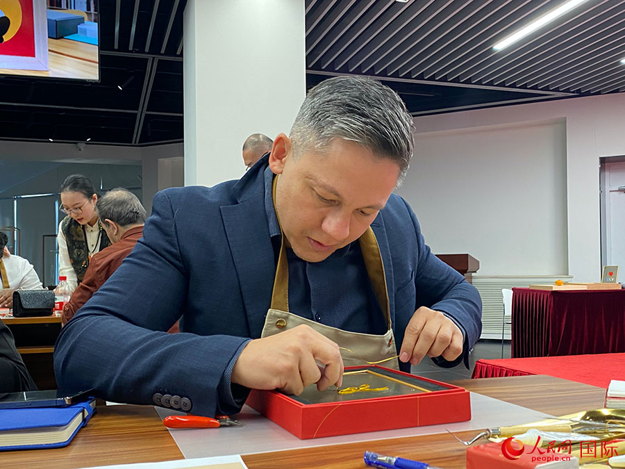 2023“一帶一路”媒體合作論壇聯(lián)合采訪團(tuán)團(tuán)員，親身體驗(yàn)景泰藍(lán)工藝。人民網(wǎng)記者 于洋攝