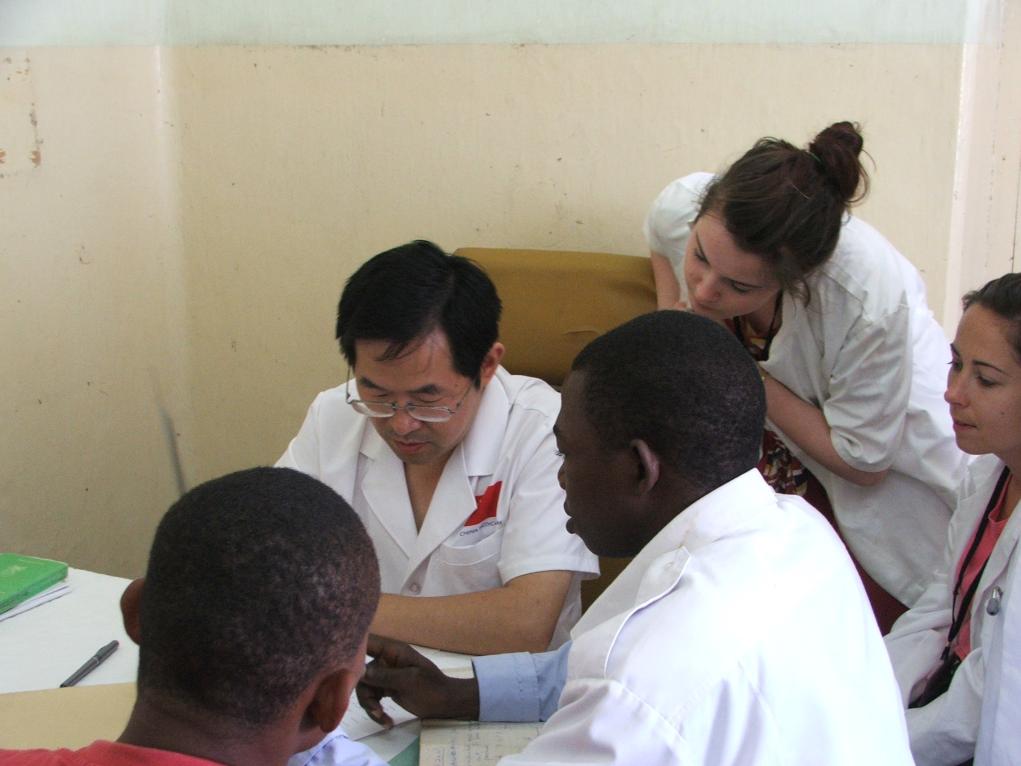 2011年7月22日，在坦桑尼亞桑給巴爾納茲莫加醫(yī)院外科門診，中國第24批援桑給巴爾醫(yī)療隊隊長盧建林為當?shù)鼗颊咴\治并帶教實習生。新華社發(fā)（國家衛(wèi)生健康委供圖）