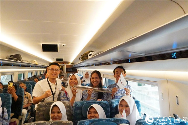 第一次乘坐雅萬高鐵動(dòng)車組的學(xué)生們與動(dòng)車組模型合影。人民網(wǎng)記者曹師韻攝