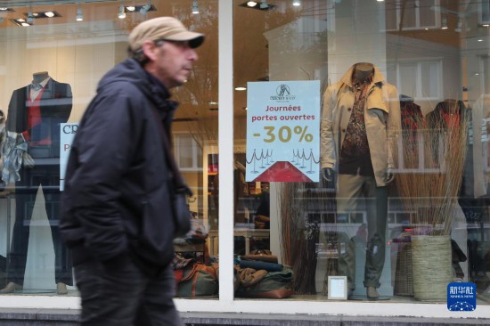  10月31日，一名男子從比利時布魯塞爾一家貼有打折信息的店鋪前走過。新華社記者 趙丁喆 攝