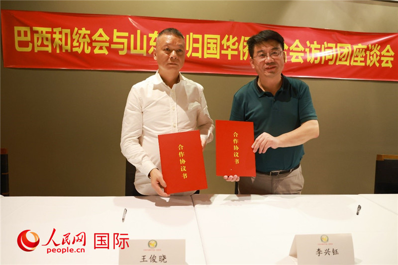 中國僑聯副主席、山東省僑聯主席李興鈺（右）與巴西和統會會長王俊曉簽署合作協議書。人民網記者 陳海琪攝