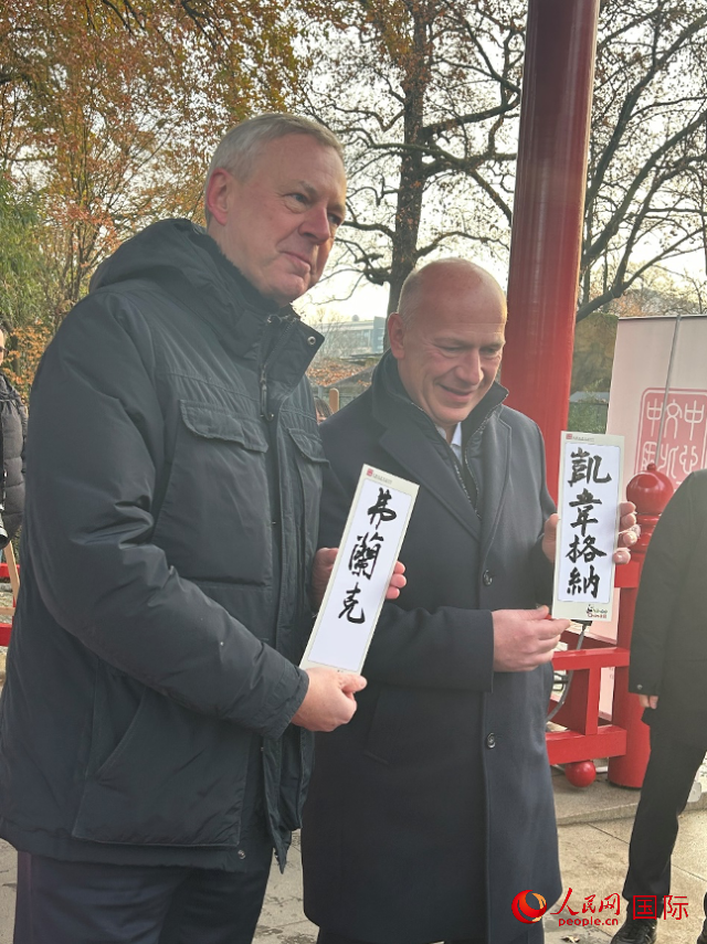 柏林市長韋格納（右）、動物園監(jiān)事會主席布魯克曼（左）手持中國文化中心工作人員現(xiàn)場手書的中文名字。人民網(wǎng)記者 徐馨攝