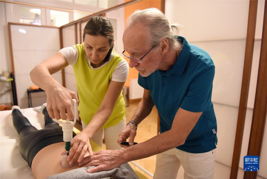 12月12日，在奧地利維也納，科格勒醫(yī)生（右）和助手在為病人進(jìn)行拔罐治療。新華社記者 賀燦鈴 攝