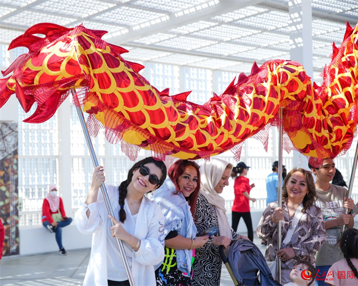 游客體驗舞龍。 人民網(wǎng) 塔里克·易卜拉欣攝