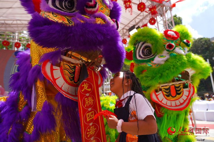 小朋友與舞獅表演者互動(dòng)。人民網(wǎng)記者 黃煒鑫攝