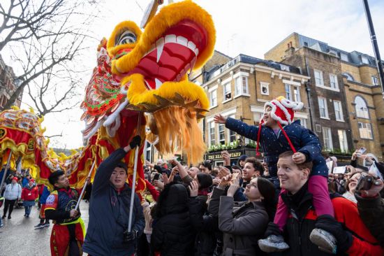 2月11日，人們?cè)谟?guó)倫敦的新春巡游活動(dòng)中觀看舞龍表演。新華社發(fā)（史蒂芬·程攝）