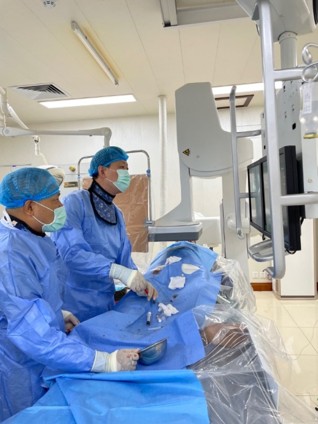 李凱教授（右）和劉海濤教授（左）為患者行TACE手術(shù)。中國(guó)駐老撾大使館供圖