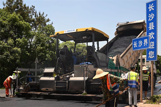 工人正在進行“極薄磨耗層”路面的鋪筑。受訪單位供圖