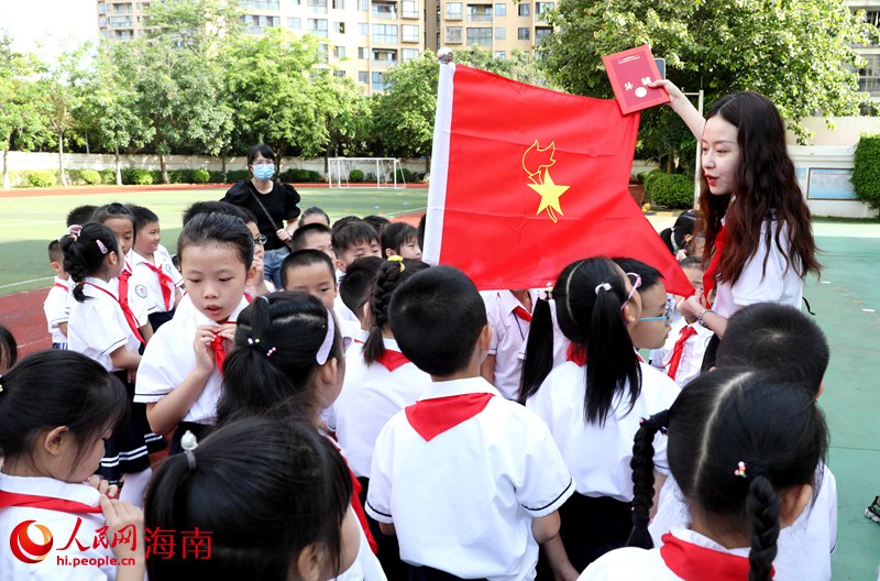 老師向少先隊(duì)員展示隊(duì)旗。人民網(wǎng) 符武平攝