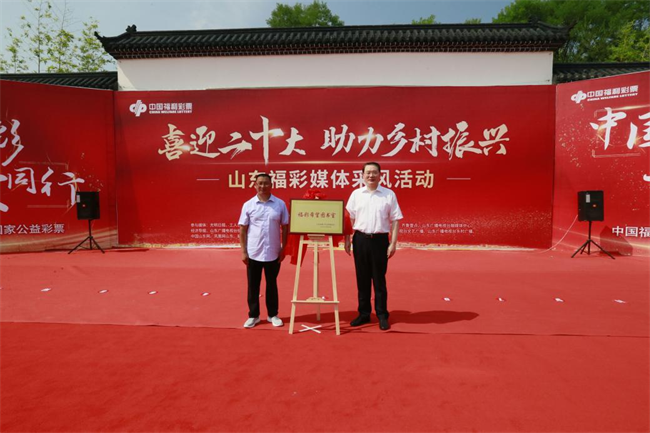 省福彩中心主任王偉與沂源縣徐家莊中心學校校長傅懷佳共同為“福彩希望圖書室”揭牌。 山東省福彩供圖）
