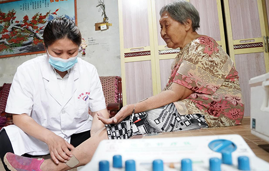 護理團隊醫(yī)生為老人進行低頻功能康復。陳佳兵攝