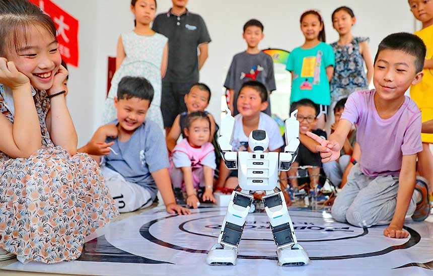 2022年7月19日，河北省秦皇島市海港區(qū)白塔嶺街道秦皇半島第二社區(qū)內(nèi)，小朋友正在觀看“機(jī)器人跳舞”。 曹建雄攝