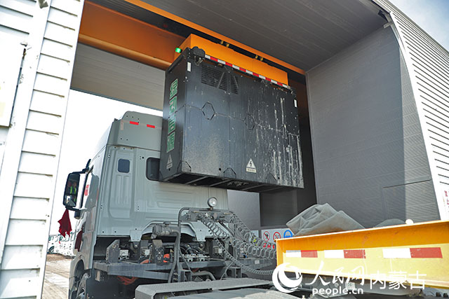 萬利新能源數(shù)字陸港里，正在充換電站進行換電的重卡。人民網(wǎng)記者 趙夢月攝