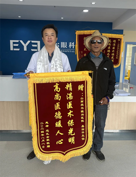 達(dá)瓦老人向吳四華（左）贈(zèng)送錦旗。受訪者供圖