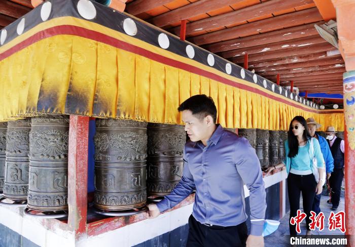 圖為外籍嘉賓體驗(yàn)藏族傳統(tǒng)轉(zhuǎn)經(jīng)筒。　馬銘言 攝