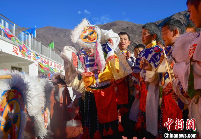 圖為加查縣安繞鎮(zhèn)小學學生在試穿藏戲面具?！∝暩聛硭?攝