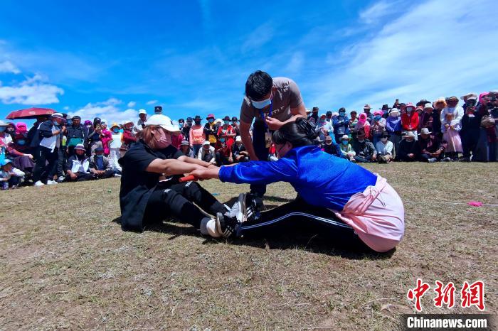 圖為當(dāng)?shù)孛癖娺M(jìn)行蹬棍比賽?！±铍h 攝