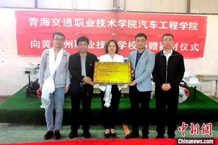 圖為李富香(中)代表學(xué)校為州縣技校捐贈器材。(資料圖) 青海省教育廳供圖