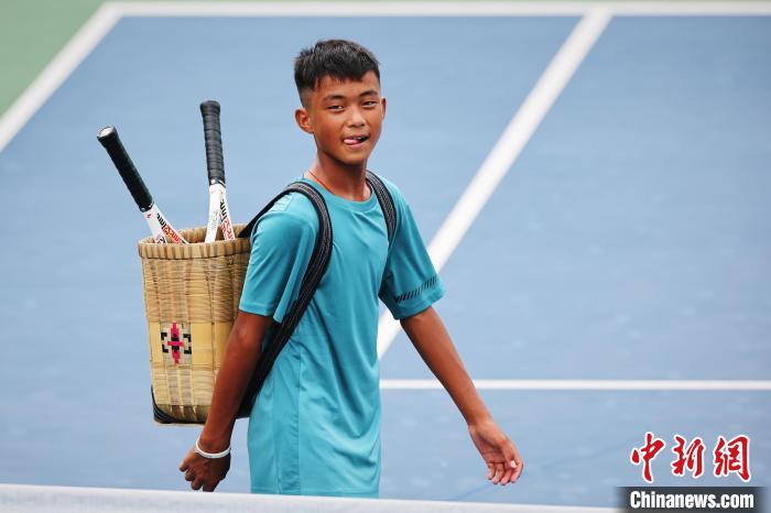 王發(fā)背著背簍在賽場上。　李建藝 攝