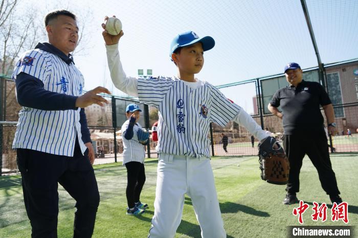 圖為教練指導小棒球手擲球技術。　馬銘言 攝