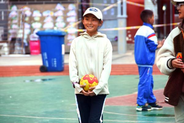 在高原上教孩子們打手球，“慢慢兒來(lái)，甭著急！”