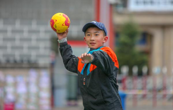 在高原上教孩子們打手球，“慢慢兒來(lái)，甭著急！”