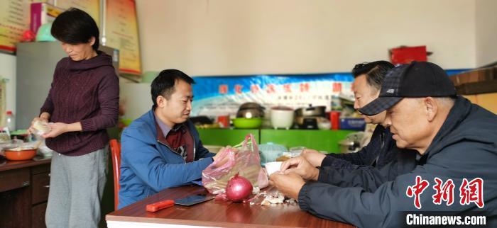 圖為扶貧路上“臨時(shí)一家人”準(zhǔn)備午餐?！∥航ㄜ?攝