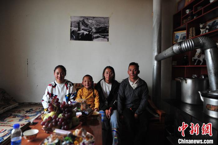 圖為8月12日，2018年7月從距那曲市色尼區(qū)城區(qū)那曲鎮(zhèn)90千米外的古露鎮(zhèn)當(dāng)桑村搬遷至城區(qū)的旦增(右一)與家人在80多平方米的新家合影(資料圖)?！垈?攝